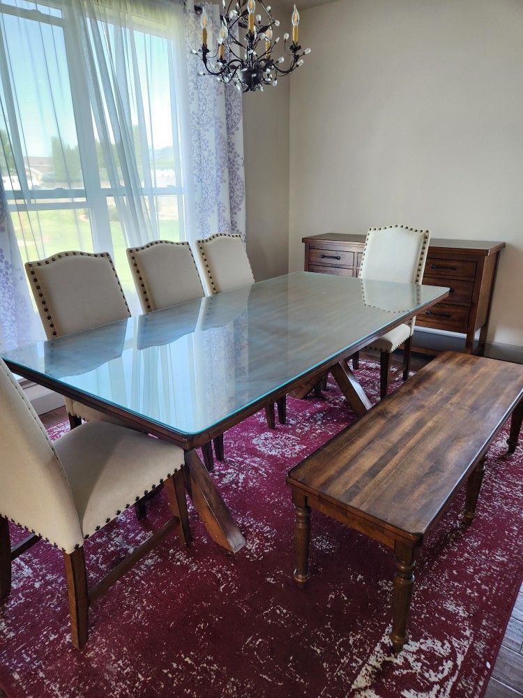 Dining table with glass top and chairs and bench