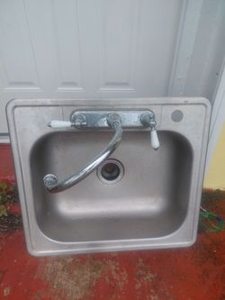 Single basin aluminum kitchen sink with faucet.
