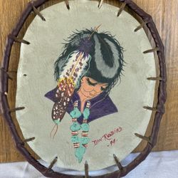vintage Native American art piece featuring a portrait painted on a leather buffalo shield, created by artist Don Redbird in 1994. 