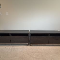 This is a pair of IKEA Bestå TV units with high gloss doors and a black-brown finish. 