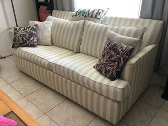 Striped sofa-bed with decorative pillows