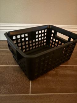 black plastic storage basket featuring an open square grid pattern and built-in side handles