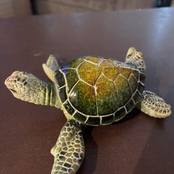 This green sea turtle figurine is an ideal coastal decor piece for your home or office, often used to enhance desks, end tables, or bookshelves.