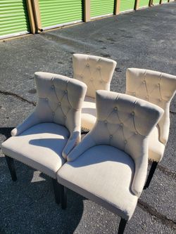 4 cream/beige linen-look tufted wingback dining chairs with arms, nailhead trim, and dark tapered legs