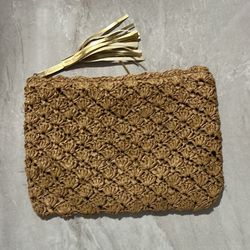 handmade, woven clutch bag with a tassel detail. 