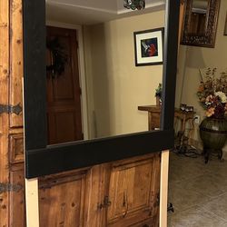 Large  black wooden dresser mirror with an arched top and a marble-like trim  