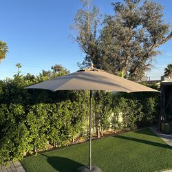10’ beige/tan Sunbrella Patio Umbrella + Rolling Base – $275
