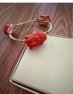 Gold tone wire bangle with three red Buddha head charms