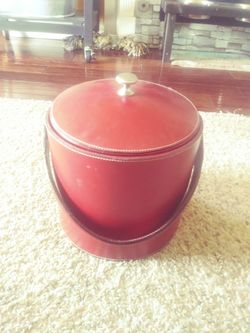 Ice cube bucket, can be used to chill wine as well. Red leather with stainless steel insert to hold ice cubes or bottles.