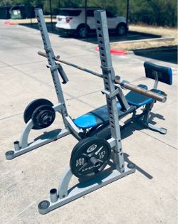 Nautilus NFB1 Olympic folding weight bench & squat rack combination featuring a silver-gray steel frame with striking blue padding and an integrated p
