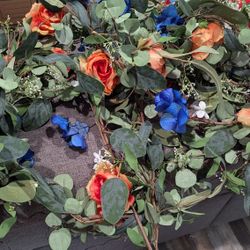 Custom garland that has orange, blue and white flowers.
