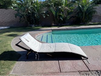 2 wicker lounge chairs with white cushions