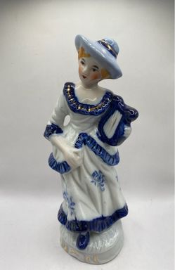 a vintage hand-painted porcelain or ceramic figurine of a Victorian-style lady or musician