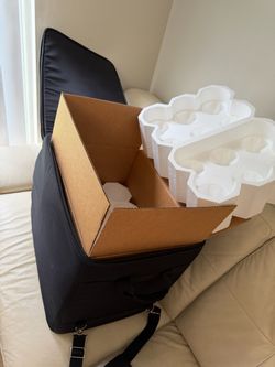specialized wine shipping box with styrofoam inserts resting inside a padded wine travel suitcase