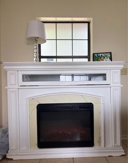 Electric fireplace heater with flame effect and realistic logs.