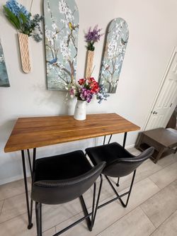 Bar-table with two black leather chairs.