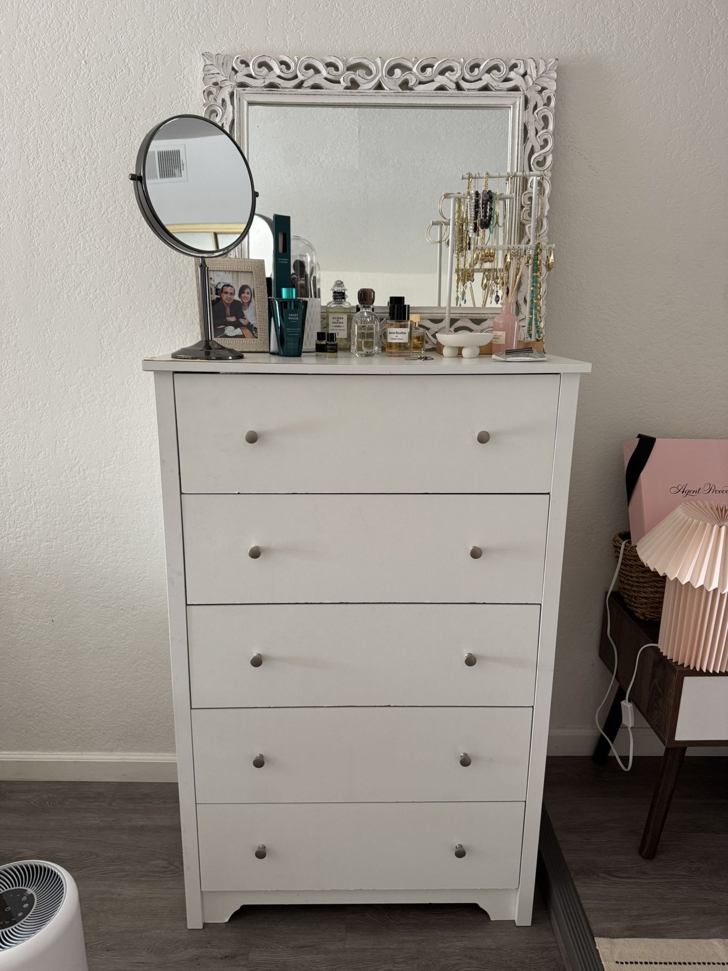 Tall white dresser with a decorative framed mirror