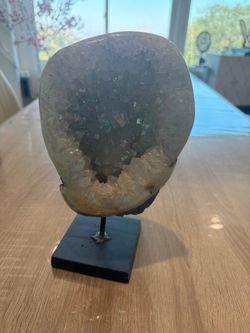 Aura Amethyst Geode mounted on a metal stand.