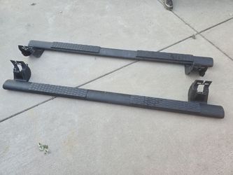Black tubular side steps extending along the crew cab of the Dodge Ram