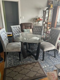 Glass table with four chairs; one of the chairs has slightly loose legs and needs the screws tightened.