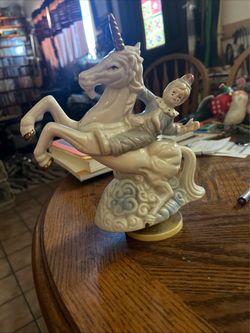 Porcelain unicorn with clown, gold accents, music box