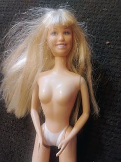 This is a 1966 Barbie doll long blonde hair with pink earrings