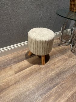 beige cable-knit round ottoman with wooden legs pouf