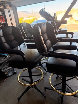 4 pcs. $50.00 each  black faux-leather swivel bar stool featuring a tufted backrest and a circular brass foot ring.