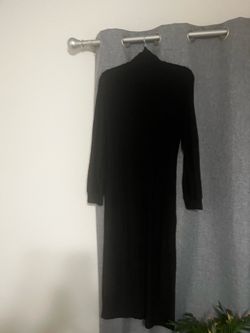 New Beautiful black midi dress has a turtleneck and long sleeves. The material is a ribbed knit. It is a solid black color throughout with a straight