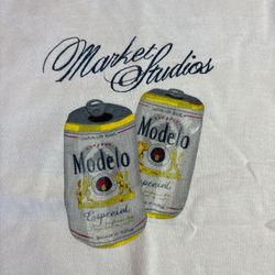 Market Studios x Modelo Especial graphic tee with tags attached.