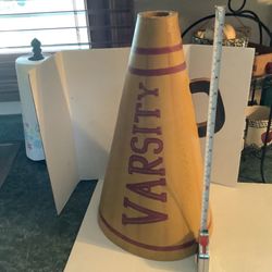 Vintage-style Gold with Burgundy/Maroon megaphone with the word "VARSITY" written on it in maroon. Features a maroon striped design at the top and bot