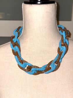 Vintage link necklace features an interlocking design of metallic mesh in turquoise blue and gold or bronze tones.