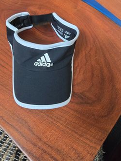 Adidas Aeroready visor provides lightweight sun protection and moisture-wicking performance for active days. This sleek black headpiece features a con