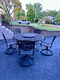 Large patio set, table is 60” diameter with 5 swivel chairs, “1 leg on table had a little damage”