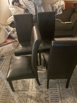 Four black high back chairs