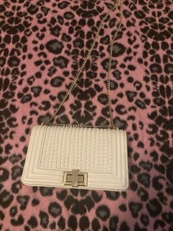 white bag with gold shoulder strap