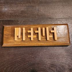wooden optical illusion plaque that spells out the name Jesus. 