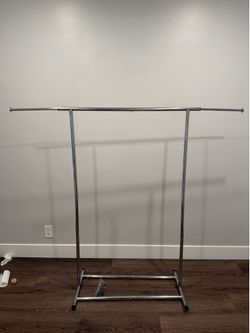 Rolling garment rack with extendable arms and adjustable height.