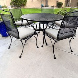 Wrought Iron Table With Umbrella Hole, Cushions, and Five Chairs