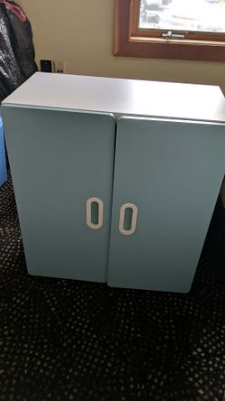 White Cupboard sits directly on the floor or stack. A Shelf inside, Colored Cupboard Doors.