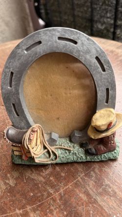 Beautiful western-style horseshoe decoration featuring cowboy boots, hat, and rope. Great for rustic home decor, farmhouse style, or cowboy-themed col