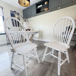 Two white wooden dinner chairs