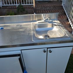 Outside Cabinet With a Small Refrigerator Small Sink And Burners