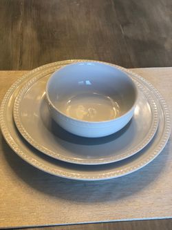 3 sets of bowls and plates with silverware, knives, and copper kettle