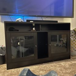 Dark Wood Entertainment Center With Two Cabinets With Glass Doors.