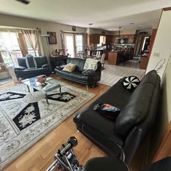 Three leather couches and the glass table