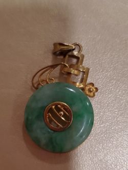 Green Jade Disc Pendant with Ornate Gold-Tone Setting — $300