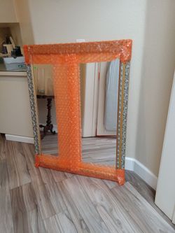 Framed mirror with silver colored frame
