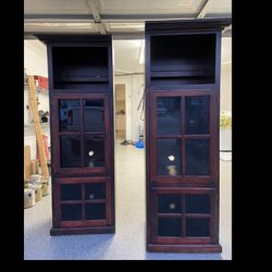 Two Wood Cabinets With Glass Shelf’s And Slicker Shelf On The Bottom 