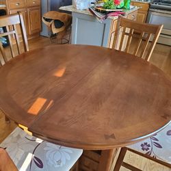 48" round table and 4 chairs, includes 18" removeavle leaf to make oval size of 66" like new. 